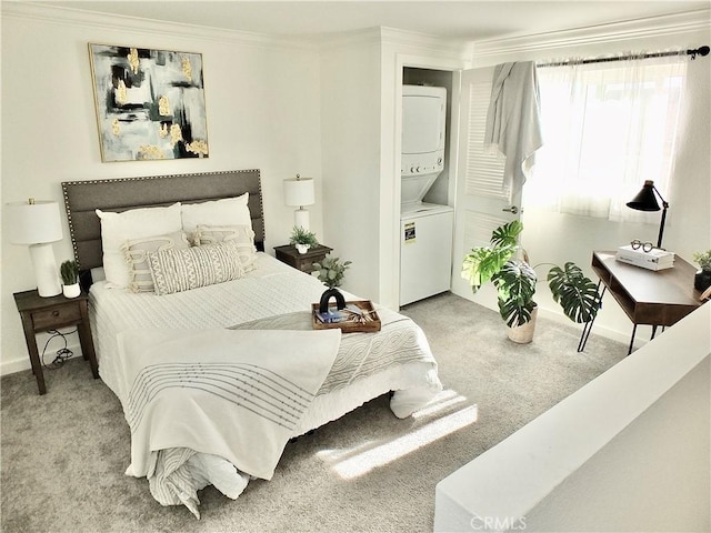 carpeted bedroom featuring crown molding and stacked washer and dryer