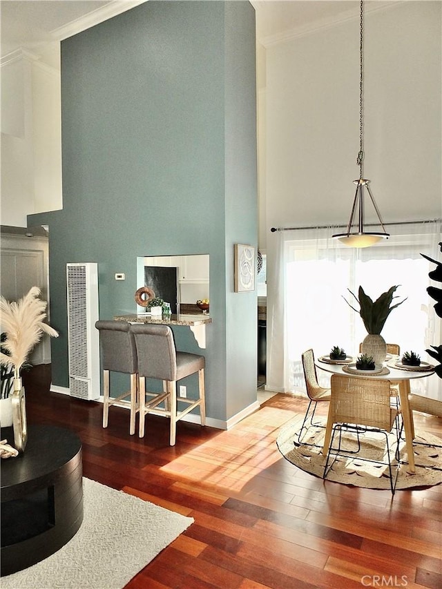 office area with wood-type flooring, crown molding, and a high ceiling