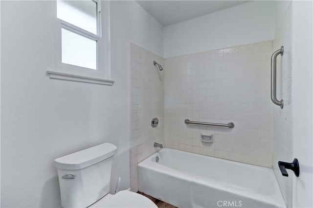 bathroom with toilet and tiled shower / bath combo