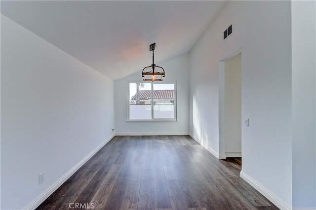 unfurnished dining area featuring dark hardwood / wood-style flooring, lofted ceiling, and a chandelier