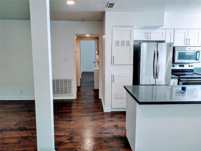 kitchen with white cabinets, stainless steel appliances, and dark wood-type flooring