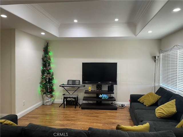 living room featuring hardwood / wood-style floors, a tray ceiling, and crown molding