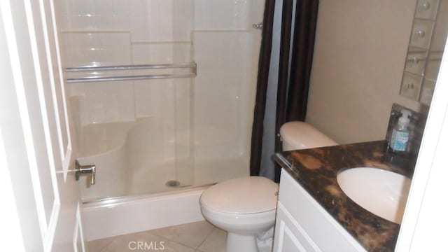 bathroom featuring tile patterned floors, vanity, toilet, and a shower with shower door