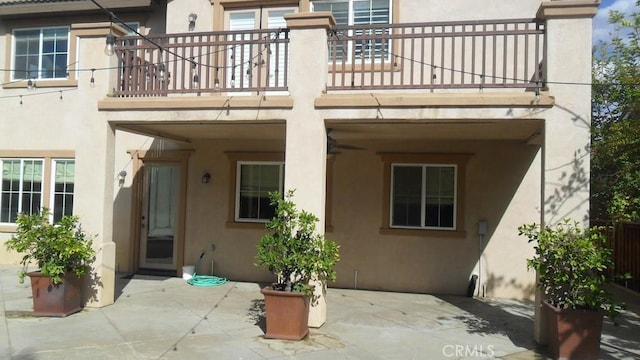 back of property featuring a patio area and a balcony