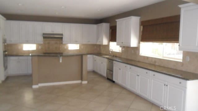 kitchen with a center island, sink, white cabinetry, and backsplash