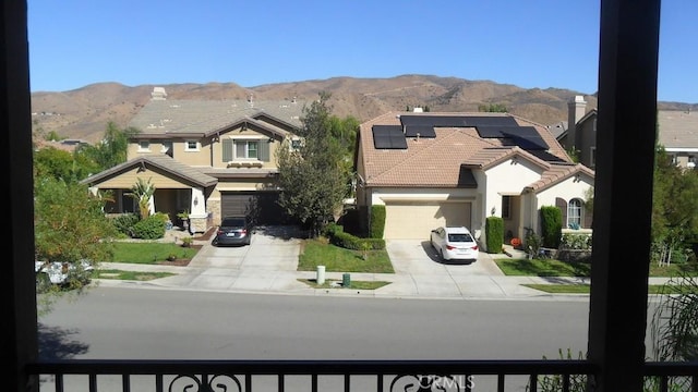 view of front of house with a mountain view, a garage, and solar panels