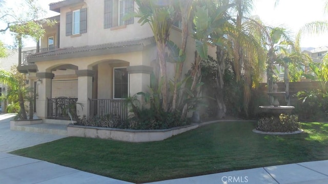 view of property exterior with covered porch and a yard