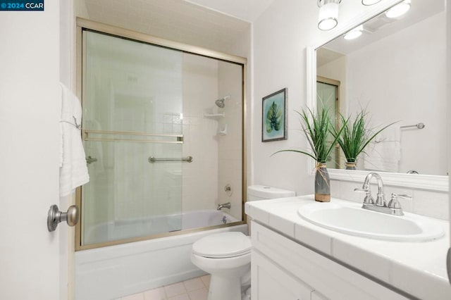 full bathroom featuring tile patterned floors, vanity, toilet, and enclosed tub / shower combo