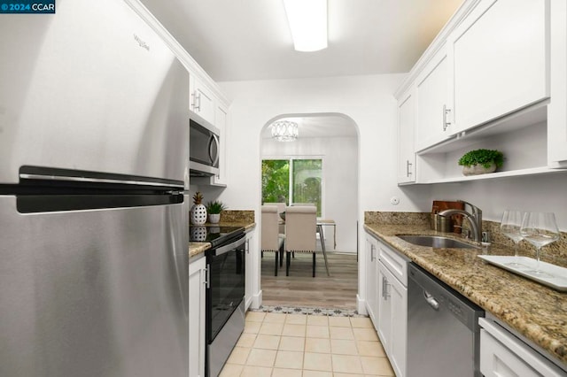 kitchen with dark stone counters, sink, light hardwood / wood-style floors, white cabinetry, and stainless steel appliances