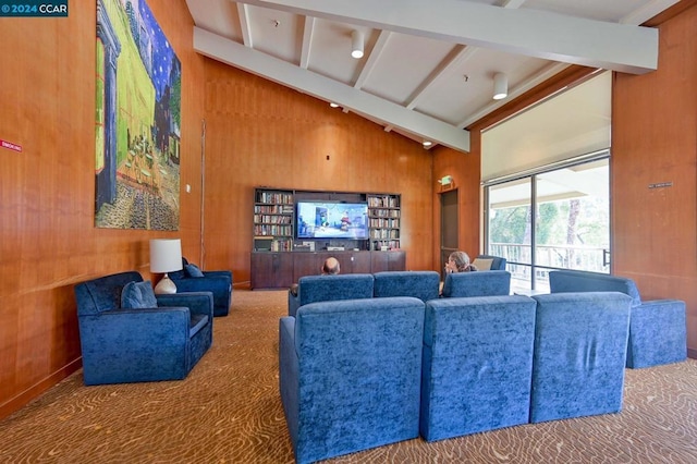 carpeted living room featuring wooden walls and lofted ceiling with beams