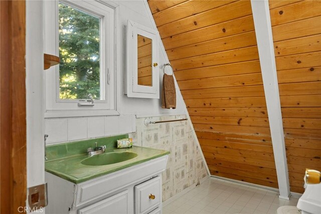 bathroom featuring wooden walls and vanity