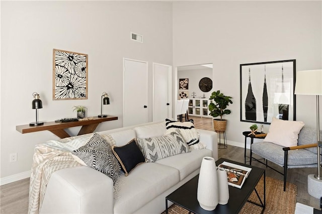 living room featuring hardwood / wood-style floors and a towering ceiling