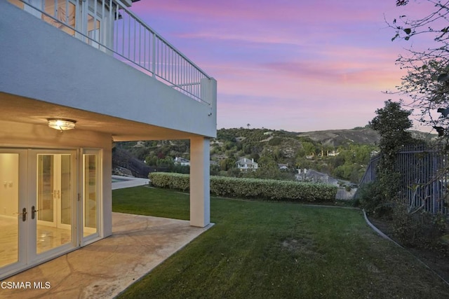 yard at dusk with a mountain view and a patio area