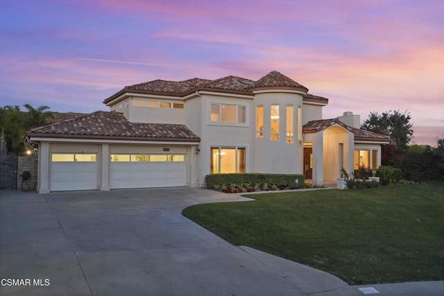 mediterranean / spanish house with a yard and a garage