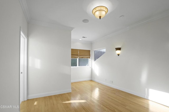 empty room with light wood-type flooring and crown molding