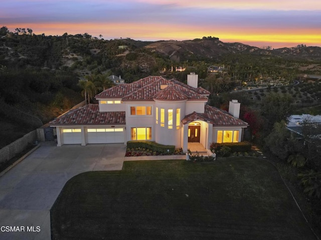 mediterranean / spanish home featuring a mountain view and a lawn