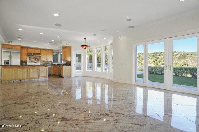 unfurnished living room featuring a healthy amount of sunlight, french doors, and crown molding