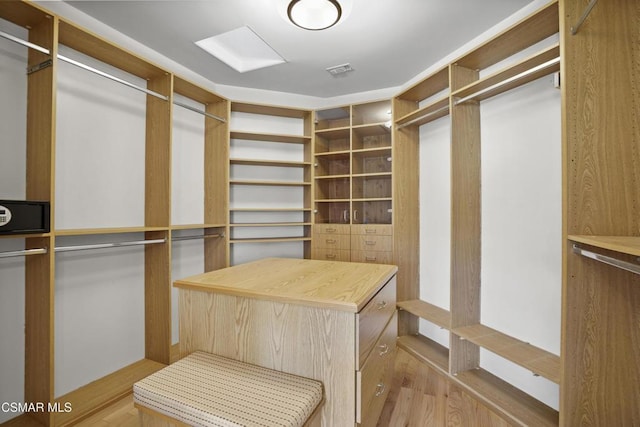 walk in closet with light hardwood / wood-style floors