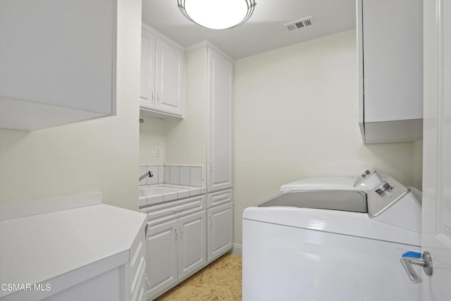 laundry room with sink, separate washer and dryer, and cabinets