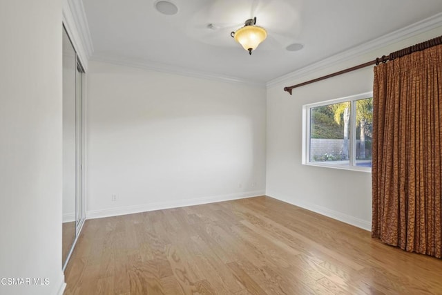 empty room featuring ornamental molding and light hardwood / wood-style floors