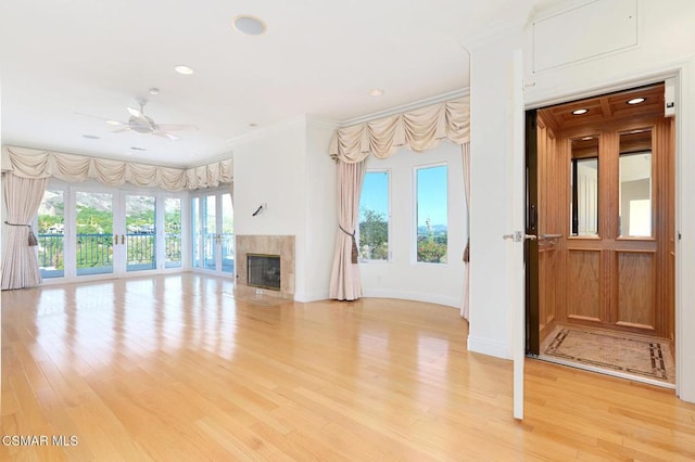 unfurnished living room featuring ceiling fan, crown molding, and light hardwood / wood-style flooring