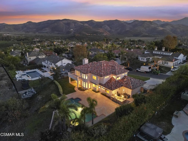 aerial view at dusk featuring a mountain view