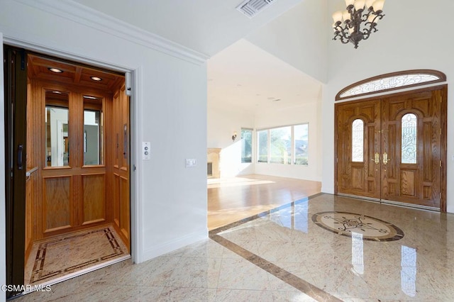 entrance foyer featuring a chandelier and ornamental molding