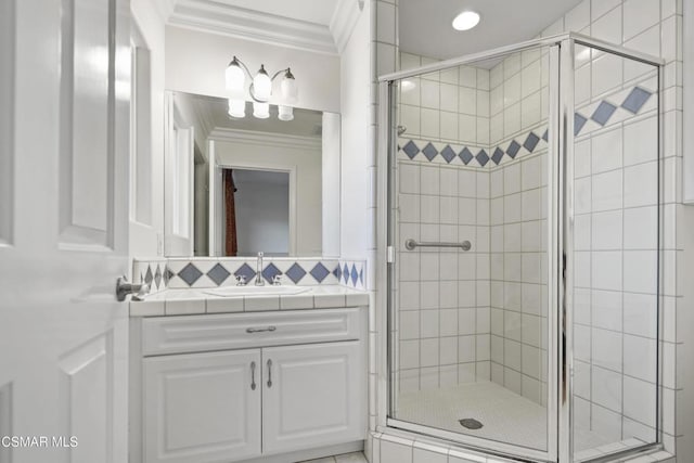 bathroom featuring vanity, a shower with shower door, and ornamental molding