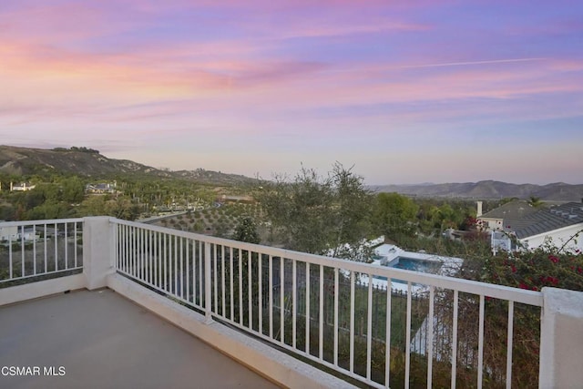 balcony at dusk featuring a mountain view