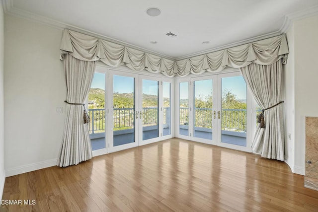 unfurnished room with ornamental molding, a wealth of natural light, and hardwood / wood-style flooring