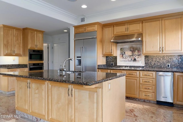 kitchen with dark stone counters, a center island with sink, appliances with stainless steel finishes, and sink