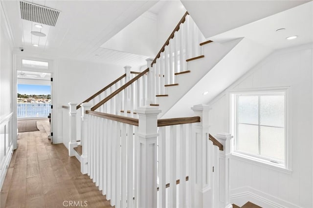 stairs with wood-type flooring and a wealth of natural light