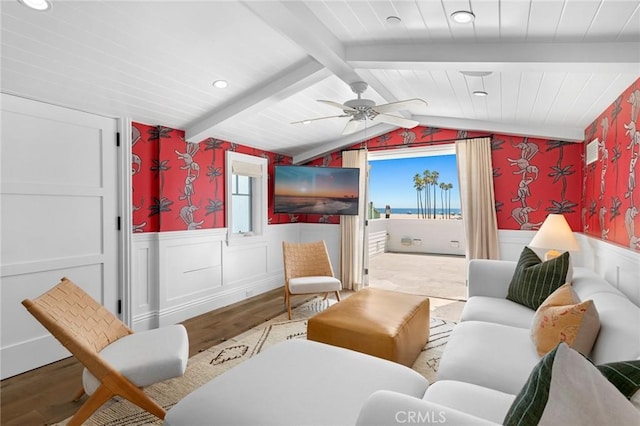 living area featuring wood-type flooring, vaulted ceiling with beams, and ceiling fan