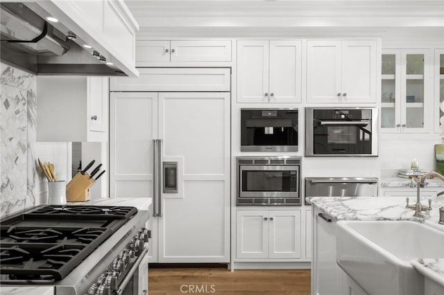 930 E Balboa Blvd, Newport Beach, CA 92661 - kitchen with built in appliances, extractor fan, a sink, white cabinetry, and tasteful backsplash