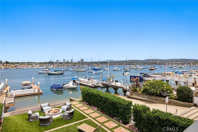 930 E Balboa Blvd, Newport Beach, CA 92661 - dock with an outdoor fire pit, a water view, view of marina, and a lawn