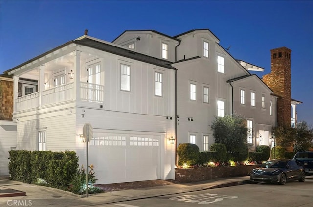 930 E Balboa Blvd, Newport Beach, CA 92661 - property exterior at twilight with a garage, board and batten siding, and a balcony