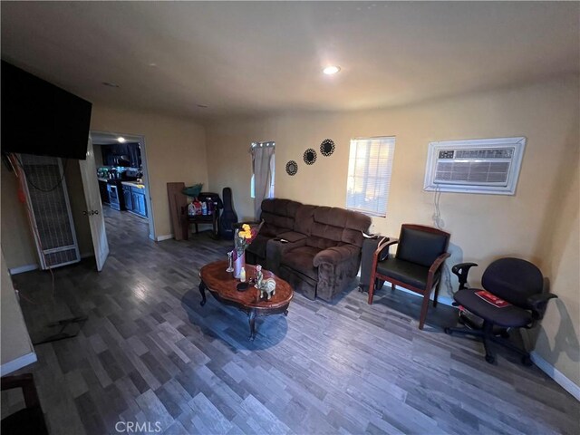 living room featuring dark hardwood / wood-style flooring and a wall mounted air conditioner