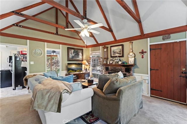 carpeted living room with ceiling fan, beam ceiling, a fireplace, and high vaulted ceiling