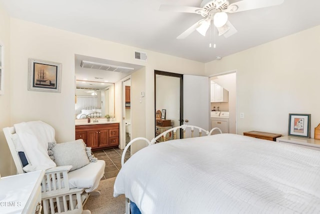 bedroom featuring tile patterned flooring, ensuite bathroom, ceiling fan, and separate washer and dryer