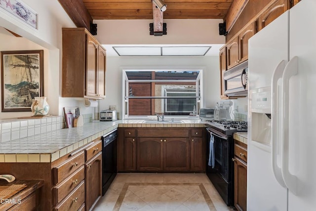 kitchen featuring beamed ceiling, sink, wood ceiling, and black appliances