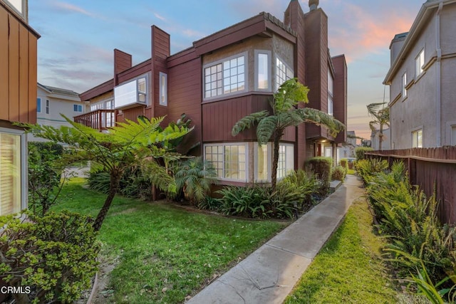 property exterior at dusk featuring a yard