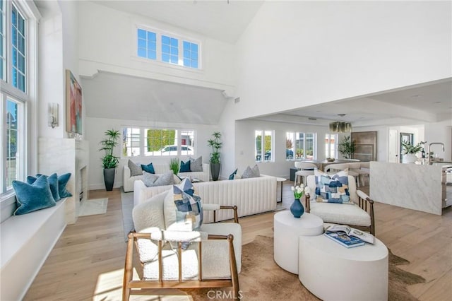 living room featuring light hardwood / wood-style flooring and high vaulted ceiling