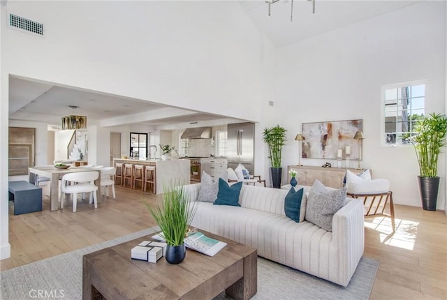 living room with a high ceiling and light hardwood / wood-style flooring