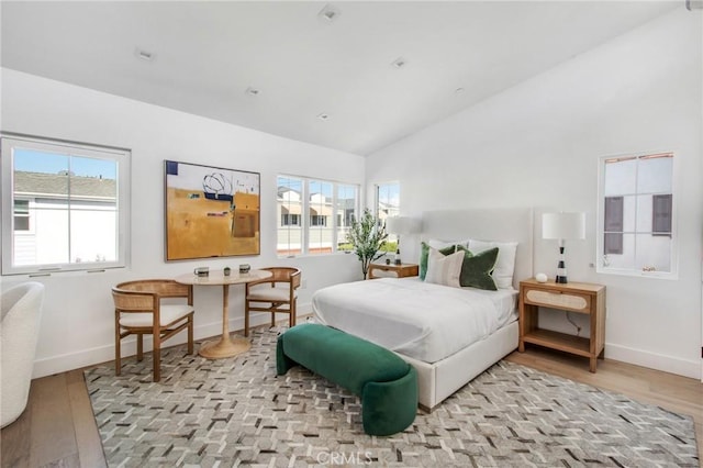 bedroom featuring light hardwood / wood-style floors and vaulted ceiling