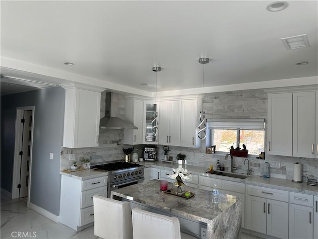 kitchen with visible vents, marble finish floor, high end stove, wall chimney range hood, and a sink