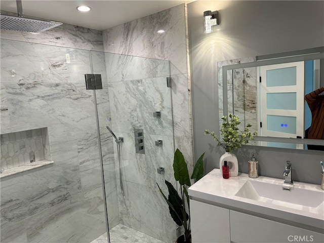 bathroom with a marble finish shower and vanity