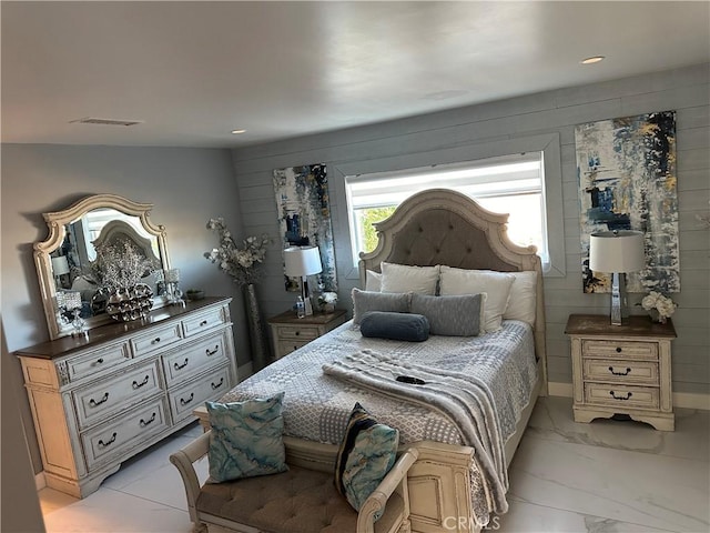 bedroom featuring marble finish floor, visible vents, and wooden walls