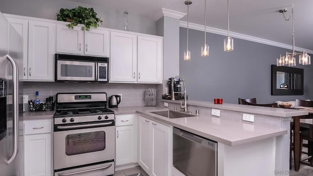 kitchen with white cabinets, sink, appliances with stainless steel finishes, decorative light fixtures, and kitchen peninsula