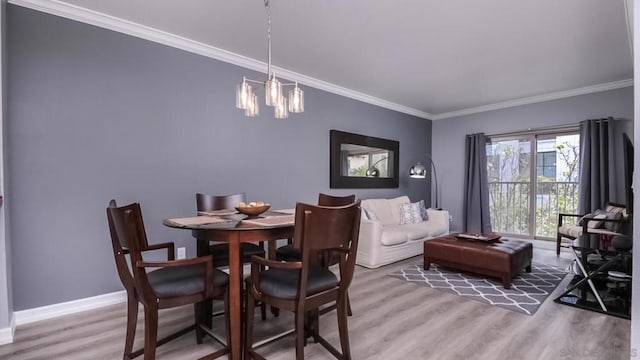 dining space with wood-type flooring, crown molding, and a chandelier