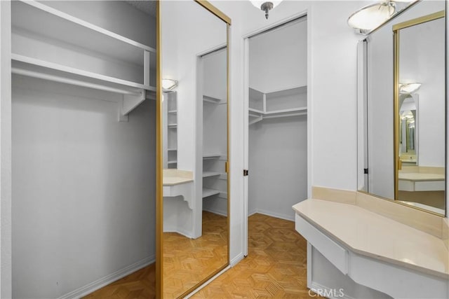 walk in closet featuring light parquet flooring